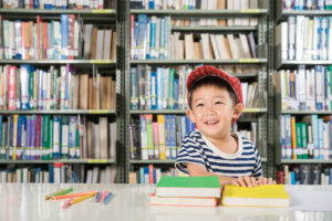 Anak laki-laki sedang baca di perpustakaan