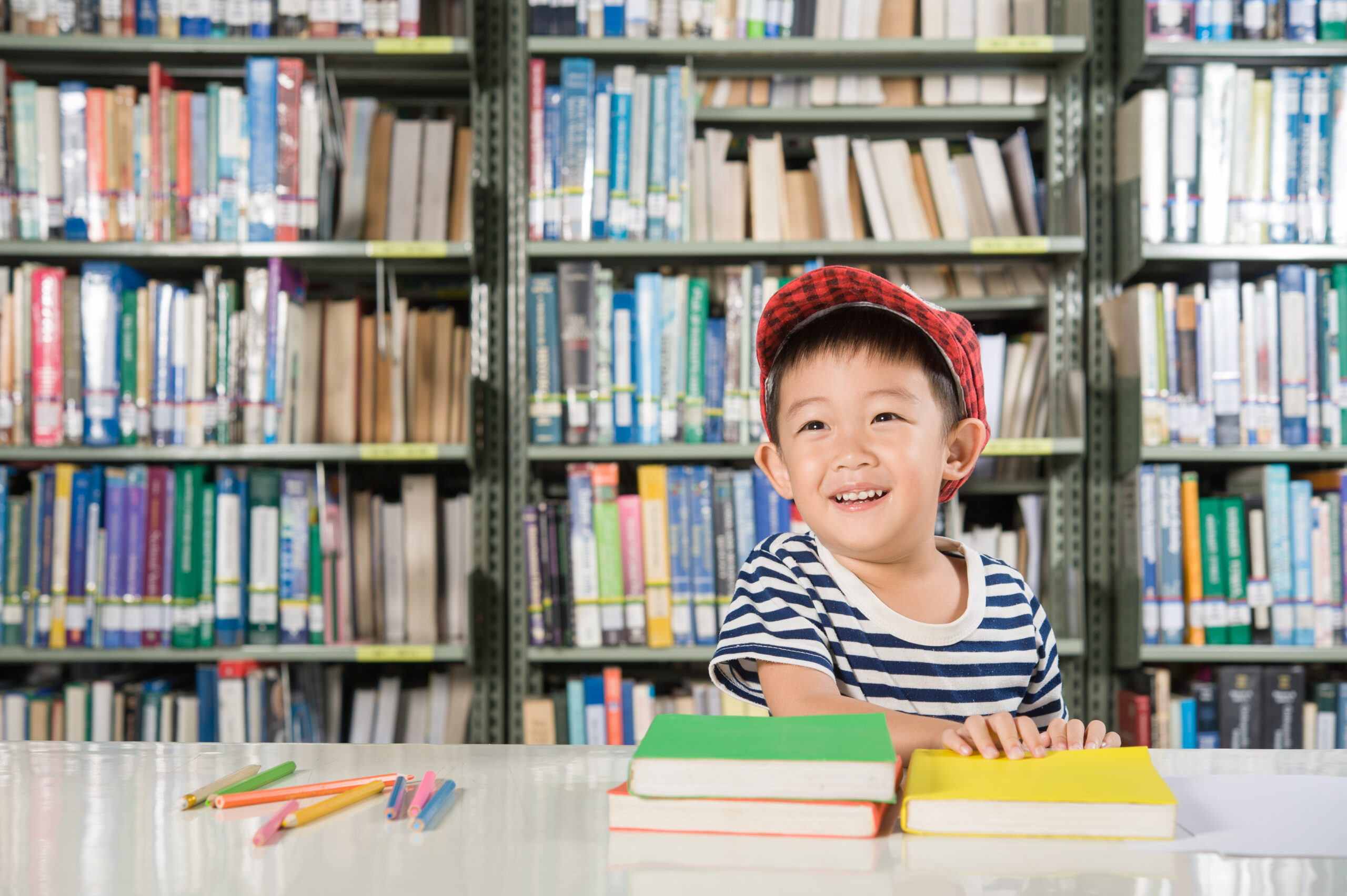 Anak laki-laki sedang baca di perpustakaan