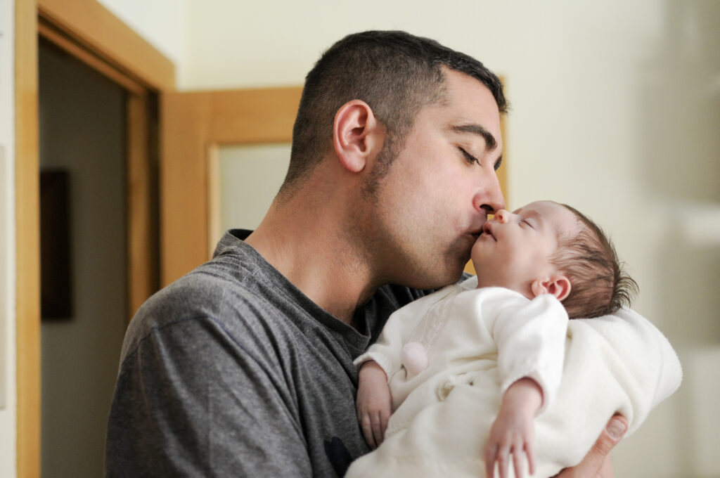 ayah sedang mencium bayi baru lahir atau newborn
